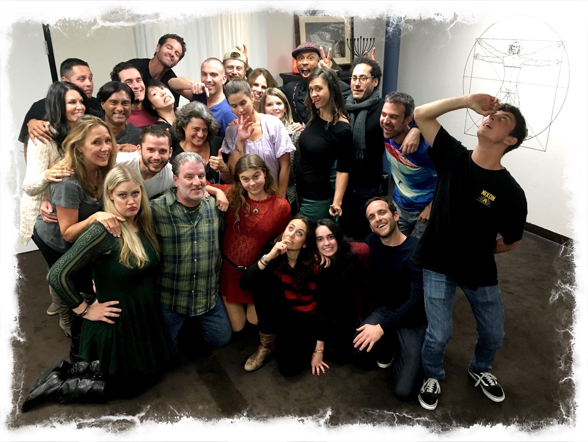 A large, diverse workshop group celebrating together after a session