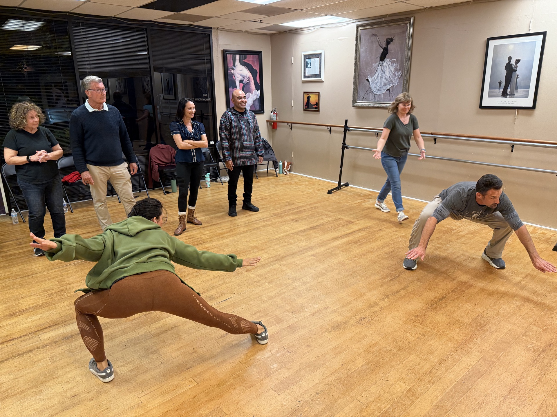 Workshop participants in mid-play, lunging and moving together